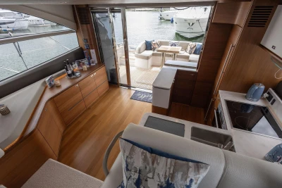 Luxurious interior of 2020 Princess F55 yacht with modern kitchen and cozy seating area.