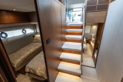 Luxurious interior of 2020 Princess F55 yacht with elegant staircase and cozy bedrooms.