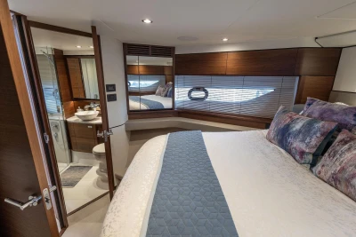 Luxurious 2020 Princess F55 yacht bedroom with elegant wood finishes and modern ensuite bathroom.