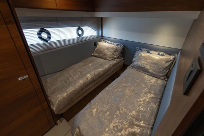 Luxurious twin cabin interior on 2020 Princess F55 yacht, featuring elegant bedding and wood accents.