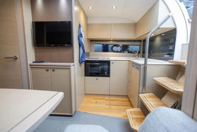 Modern interior of 2018 Princess V40 yacht with kitchen and TV setup.