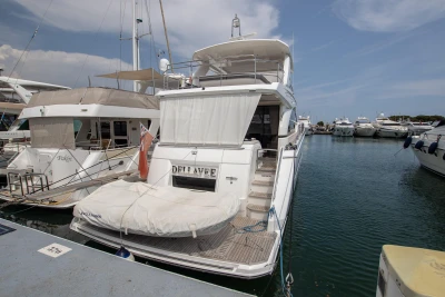 A luxurious yacht docked in a marina, featuring multiple decks and elegant design.