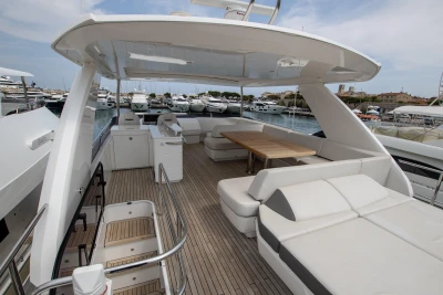 The image shows the deck of a luxury yacht with seating and a table.
