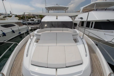 Luxurious sunbed on the front of a yacht docked in a marina.