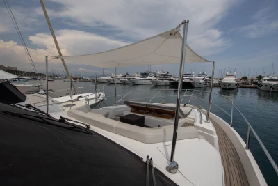 Luxury yacht with sunshade and harbor view.