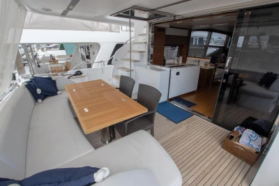 Deck area with dining table and seating on a yacht.