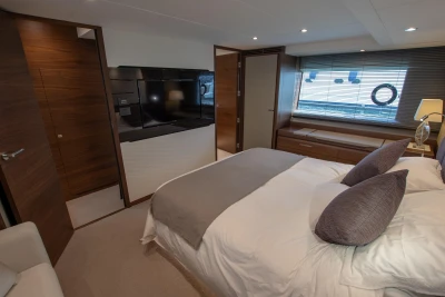 Master bedroom with double bed, wooden furniture, and large window.