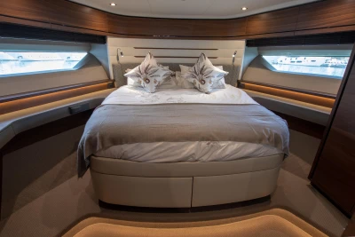 Luxurious bedroom with a large bed and elegant lighting on a yacht.