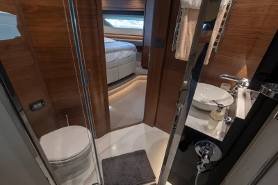 Bathroom and bedroom in a luxury yacht with modern fixtures and wood accents.