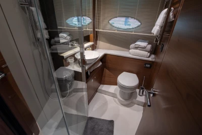 Bathroom on a yacht with shower, toilet, and sink.