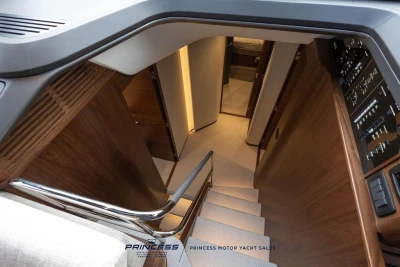 Interior view of 2026 Princess S65 yacht staircase with modern wood finish.