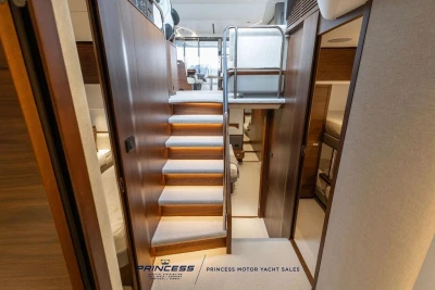 Luxurious interior of 2026 Princess S65 yacht with elegant wooden staircase and modern design.