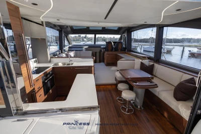 Luxurious interior of 2026 Princess S65 yacht with modern kitchen and seating area.