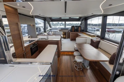 Luxurious interior of 2026 Princess S65 yacht with modern kitchen and seating area.