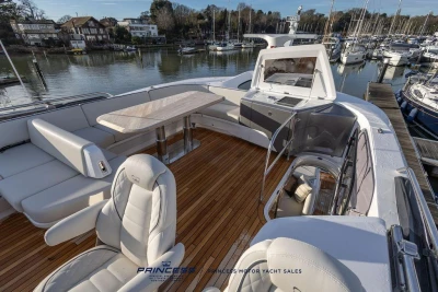 Luxurious 2026 Princess S65 yacht deck with elegant seating and scenic marina view.