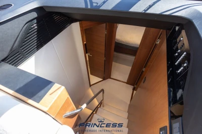 Interior view of 2019 Princess S60 yacht, showcasing elegant wooden stairs and cabin entrance.