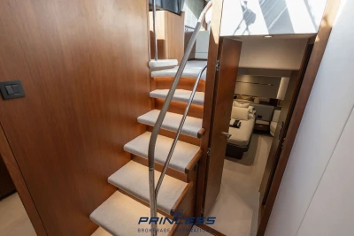 Interior of 2019 Princess S60 yacht with wooden stairs and cozy bedroom.