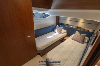 Luxurious twin cabin interior of 2019 Princess S60 yacht with elegant wood finishes.
