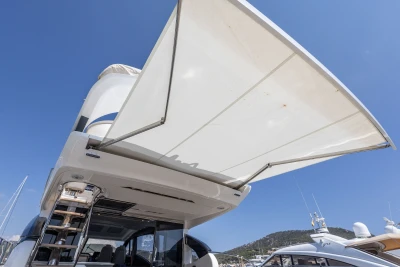 2018 Princess S60 yacht with extended sunshade under clear blue sky.