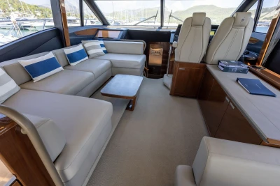 Luxurious interior of 2018 Princess S60 yacht with beige seating and nautical decor.
