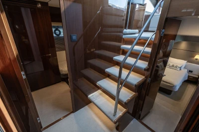 Luxurious interior of 2018 Princess S60 yacht with elegant staircase and cozy bedrooms.