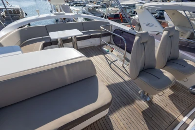 Luxurious 2018 Princess S60 yacht deck with elegant seating and table, docked at marina.