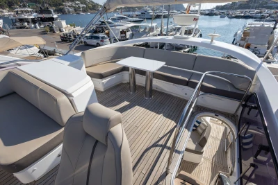 Luxurious 2018 Princess S60 yacht deck with seating and table, docked at marina.
