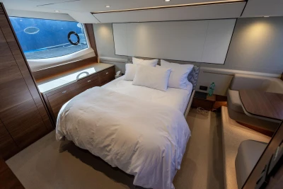 Luxurious bedroom with double bed, wooden furniture, and large window on a Princess F55 yacht.
