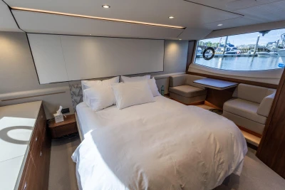Luxurious cabin with a double bed, sofa, and large window overlooking the harbor.