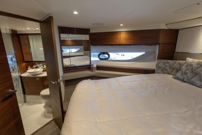 The 2022 Princess F55 cabin features an elegant bedroom with a large bed and adjoining bathroom.