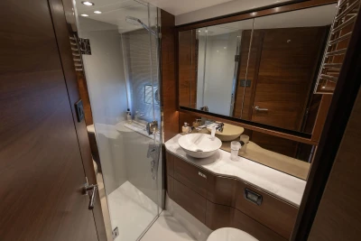 The image shows an elegant yacht bathroom with modern fixtures and wood paneling.