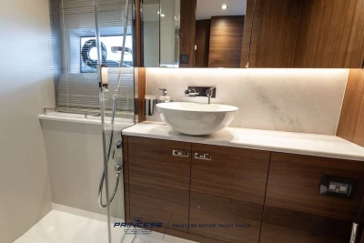 Luxurious bathroom interior of 2025 Princess F50 yacht with modern sink and wooden cabinetry.