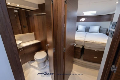 Luxurious interior of 2025 Princess F50 yacht featuring bedroom and bathroom.
