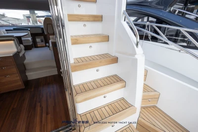 Luxurious interior of 2025 Princess F50 yacht with wooden stairs and elegant design.