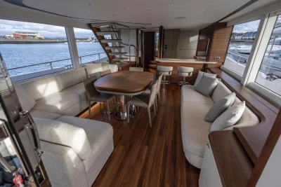 Luxurious interior of 2026 Princess X80 yacht with elegant seating and wooden flooring.
