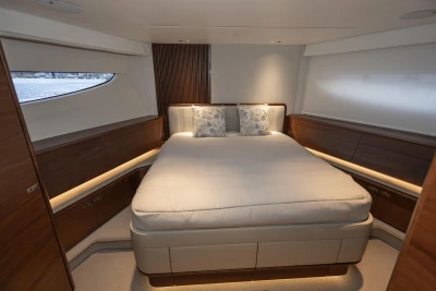 Luxurious bedroom interior of 2026 Princess X80 yacht with elegant wood finishes.