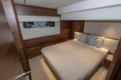 Luxurious bedroom interior of 2026 Princess X80 yacht with elegant wood paneling.