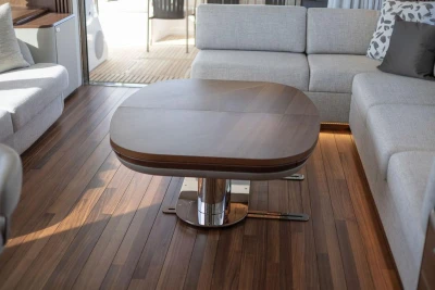 Luxurious interior of 2026 Princess X80 yacht with elegant wood table and plush seating.