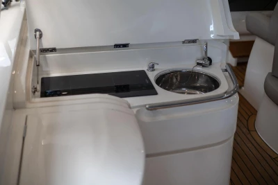 2007 Princess V48 yacht kitchenette with sink and stovetop, featuring sleek design.