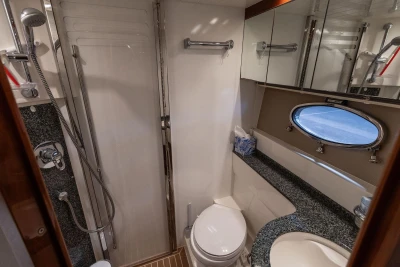Luxurious bathroom in 2007 Princess V48 yacht with shower, toilet, and porthole window.
