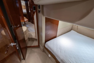 Luxurious interior of 2007 Princess V48 yacht with cozy bedroom and elegant wood finishes.